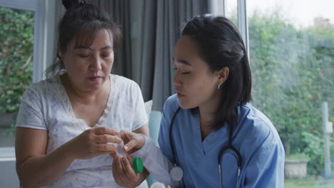 smiling asian female doctor talking to happy female patient about her medication at hospital