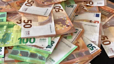 man duwt een stapel geld op tafel