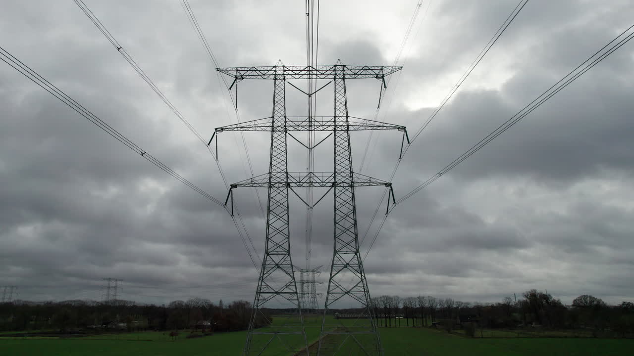 Dramatic, low angle dolly shot of transmission towers standing in the wide dutch landscape.