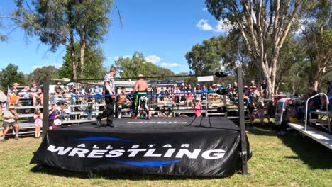 spectators watching a wrestling match outdoors