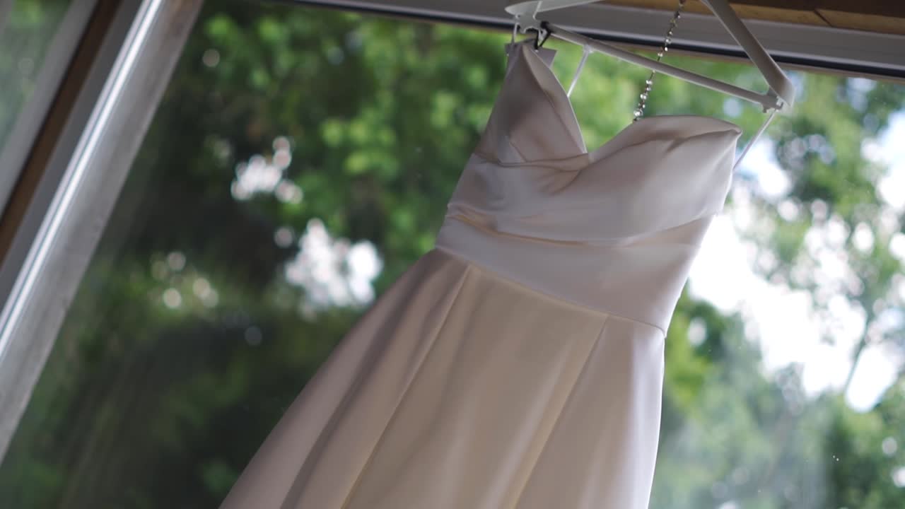 방의 열린 창문에 매달린 신부의 색 사틴 드레스의 클로즈업