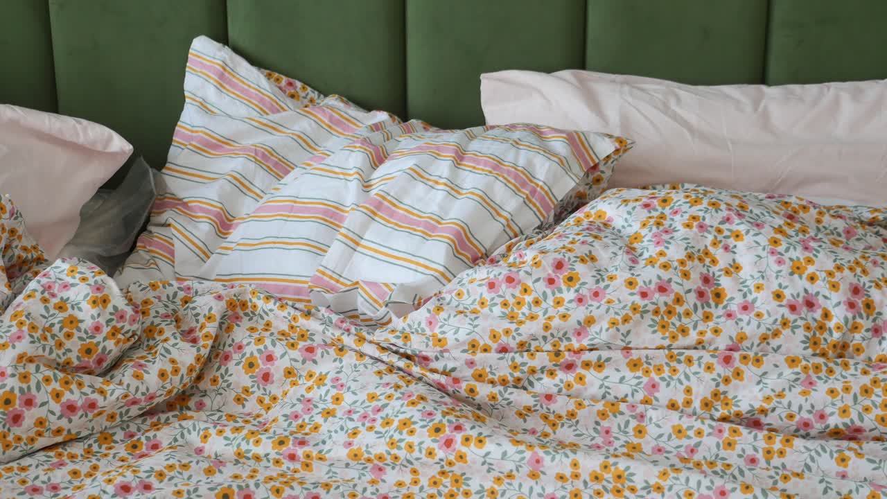 acogedor dormitorio floral con cama sin hacer