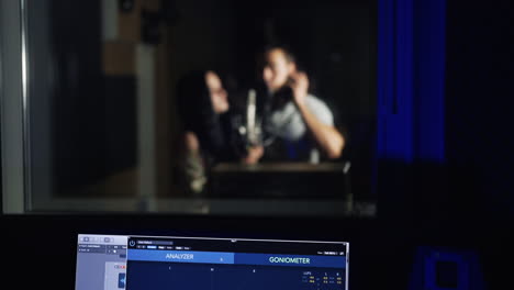 couple recording vocals in a studio