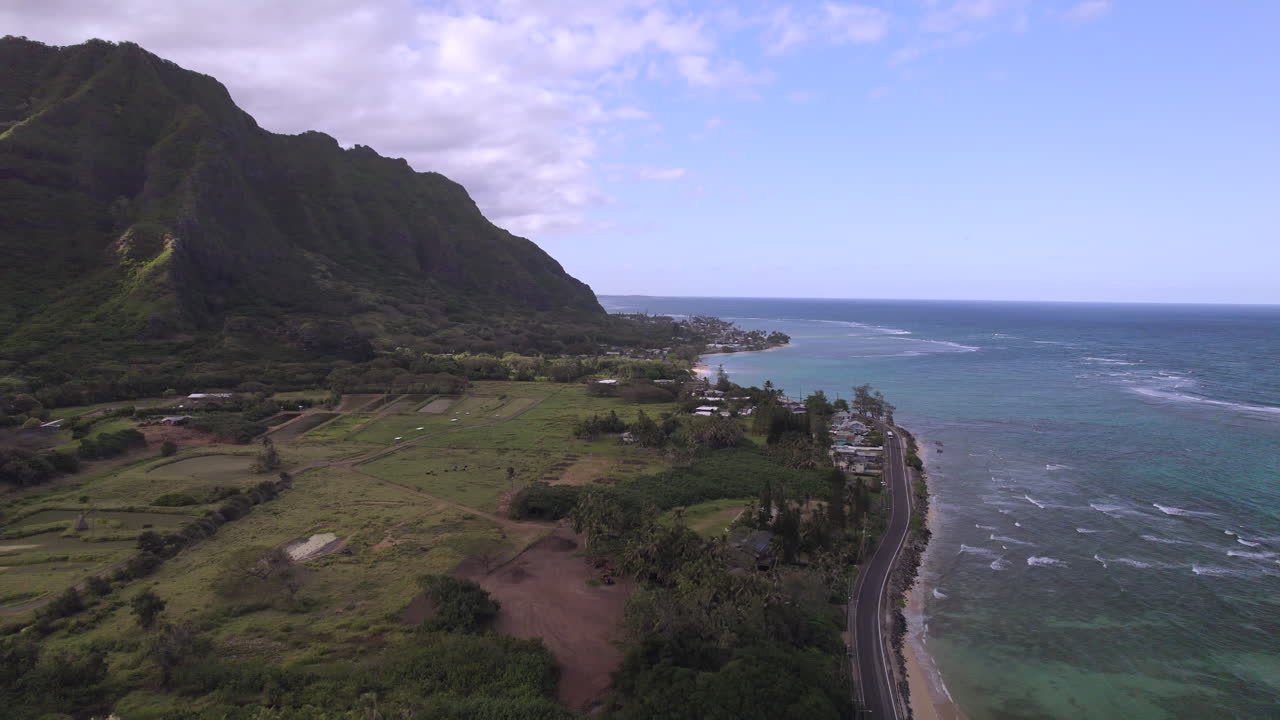 Veduta aerea sulla linea costiera a Oahu, Hawaii, che scende verso l'oceano e una strada che si snoda lungo la spiaggia