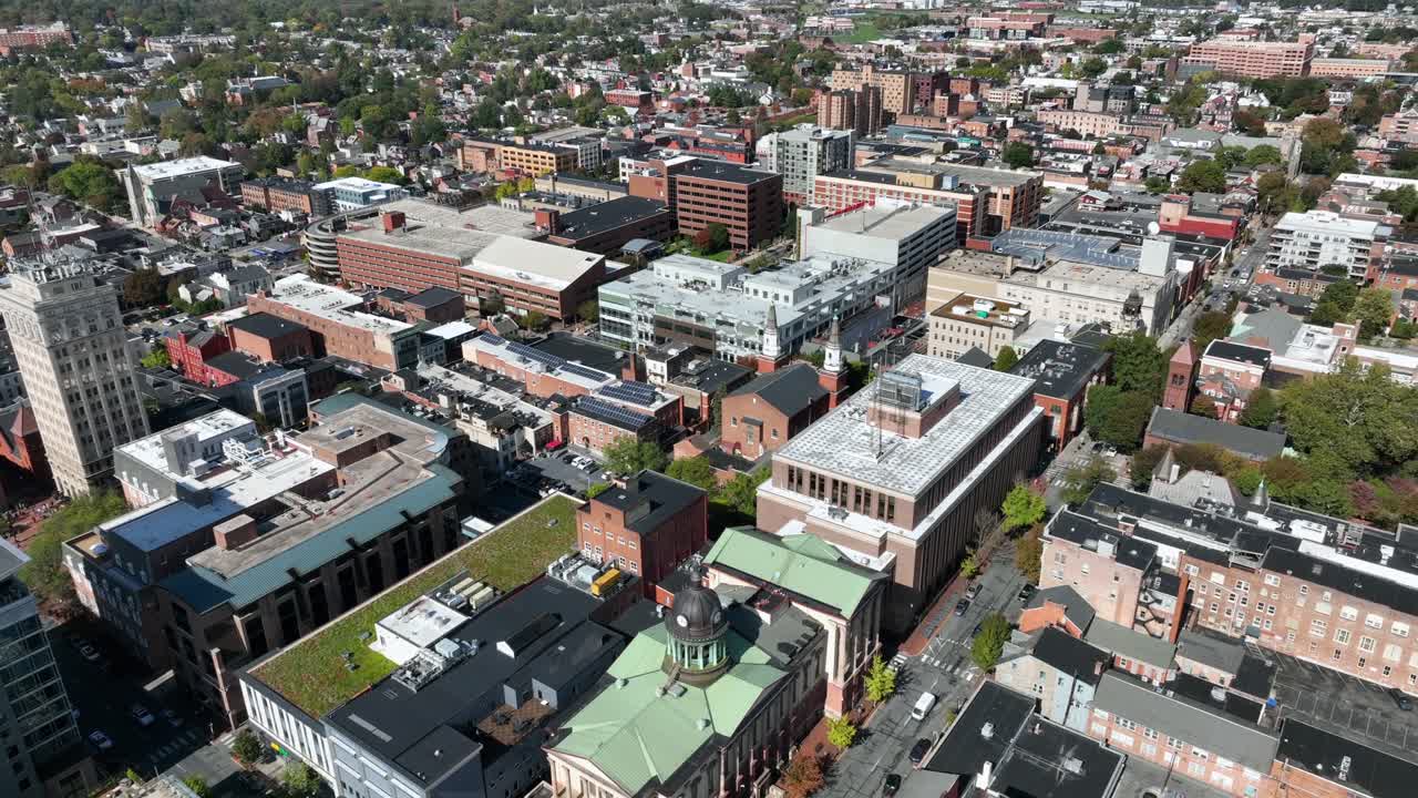 Aerial flyover of Lancaster Downtown with historic buildings, city hall and towers. Sunny day in fall season. Green rooftop garden oil office house