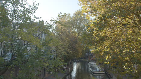 tilt down to beautiful canal with tour boats in utrecht city, the netherlands