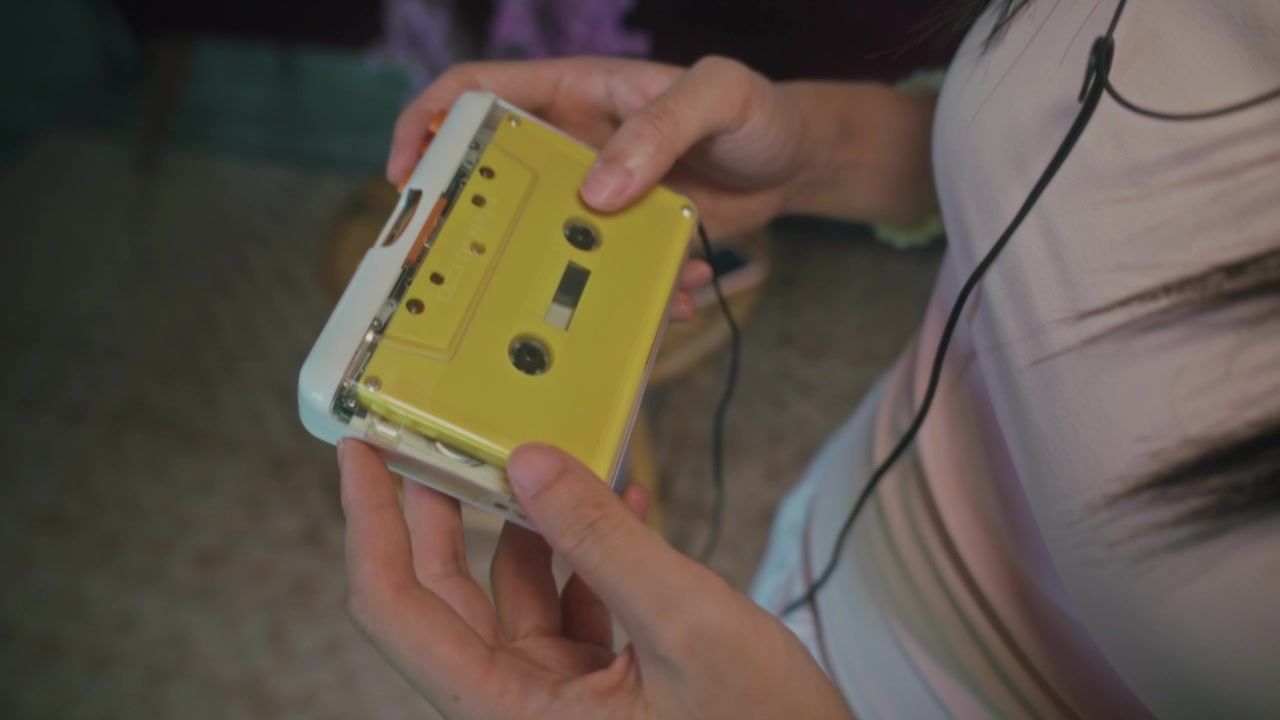 Persoon met een vintage gele cassetterecorder