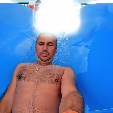 man having fun on a water slide in a water park