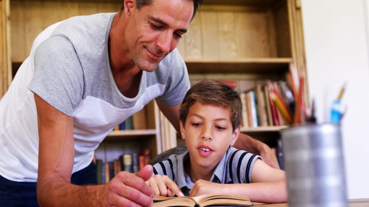 padre e hijo leyendo un libro en la sala de estudio