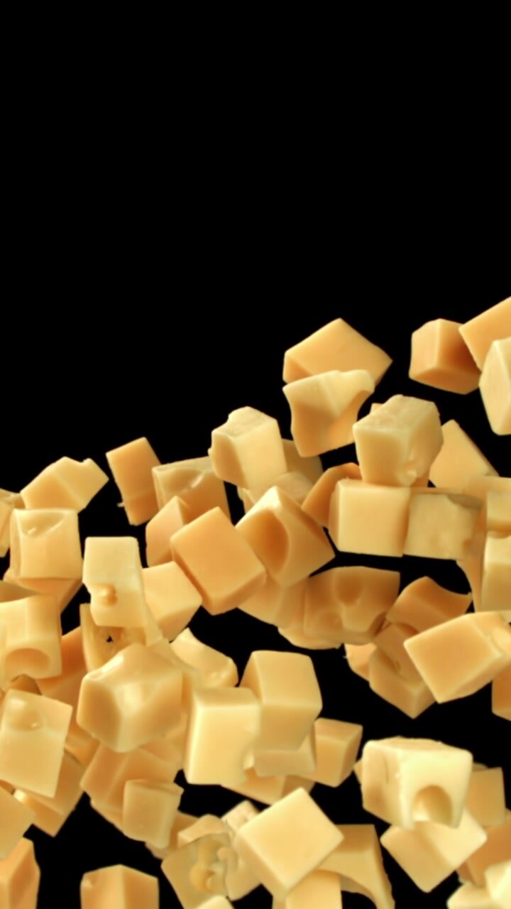Cheese Cubes Falling and Piling Up on a Black Background