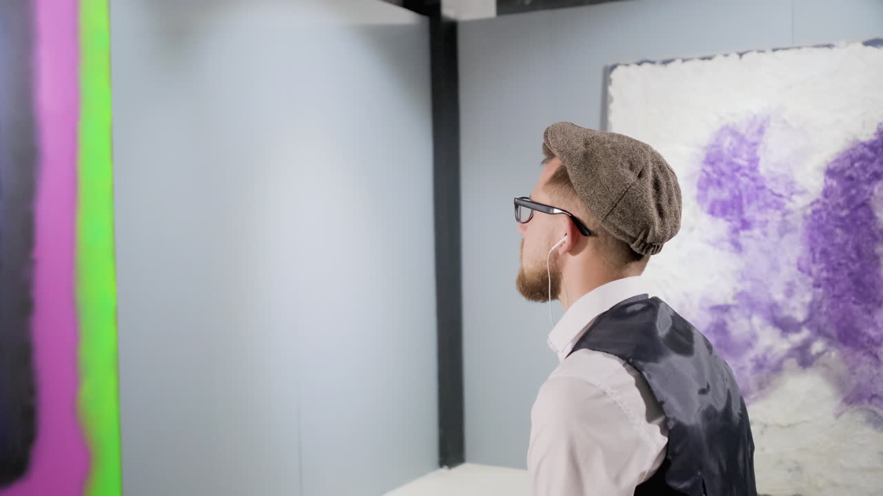 갤러리에서 추상 예술을 관찰하는 남자