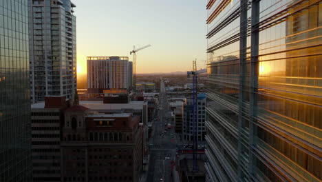 aerial view flying in middle of reflecting building, sunset in downtown phoenix, usa