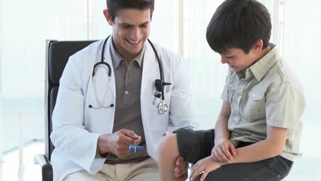 Smiling-doctor-checking-little-boys-reflexes