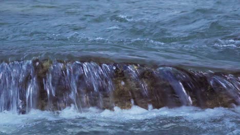 river water flows over a rock