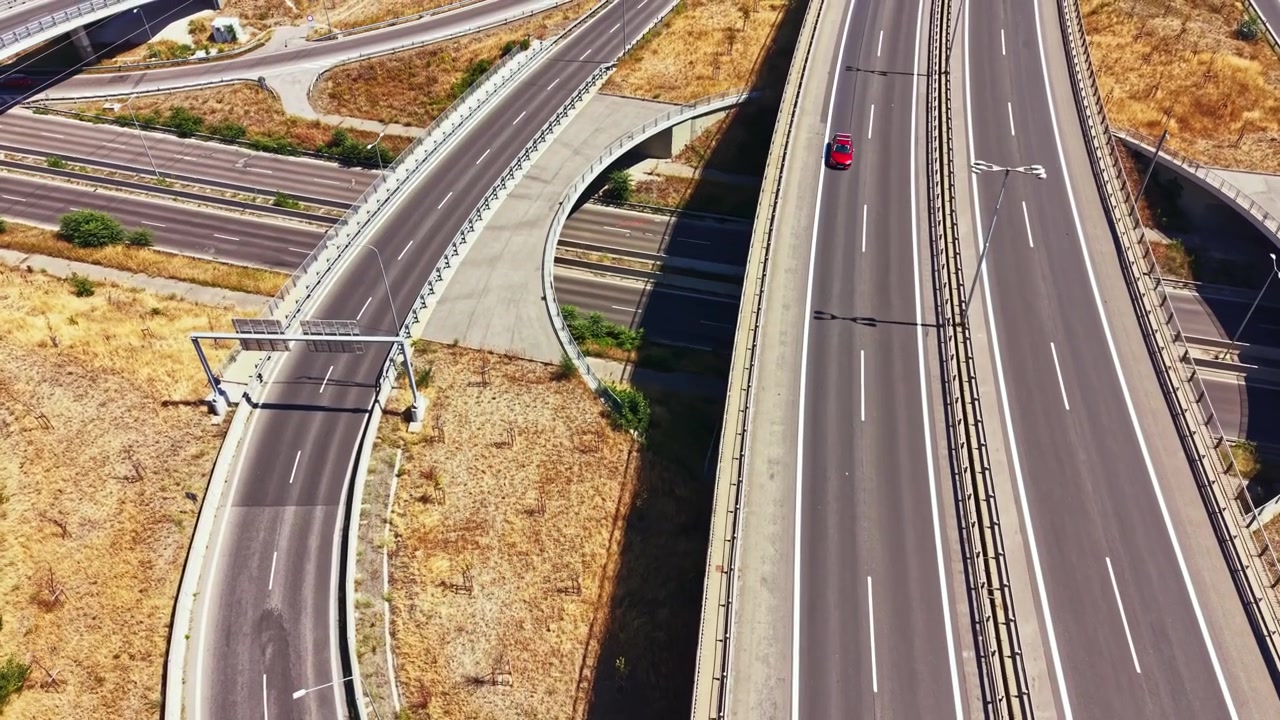 Il traffico scorre su una rotatoria in una città di giorno, con un cielo azzurro e limpido.