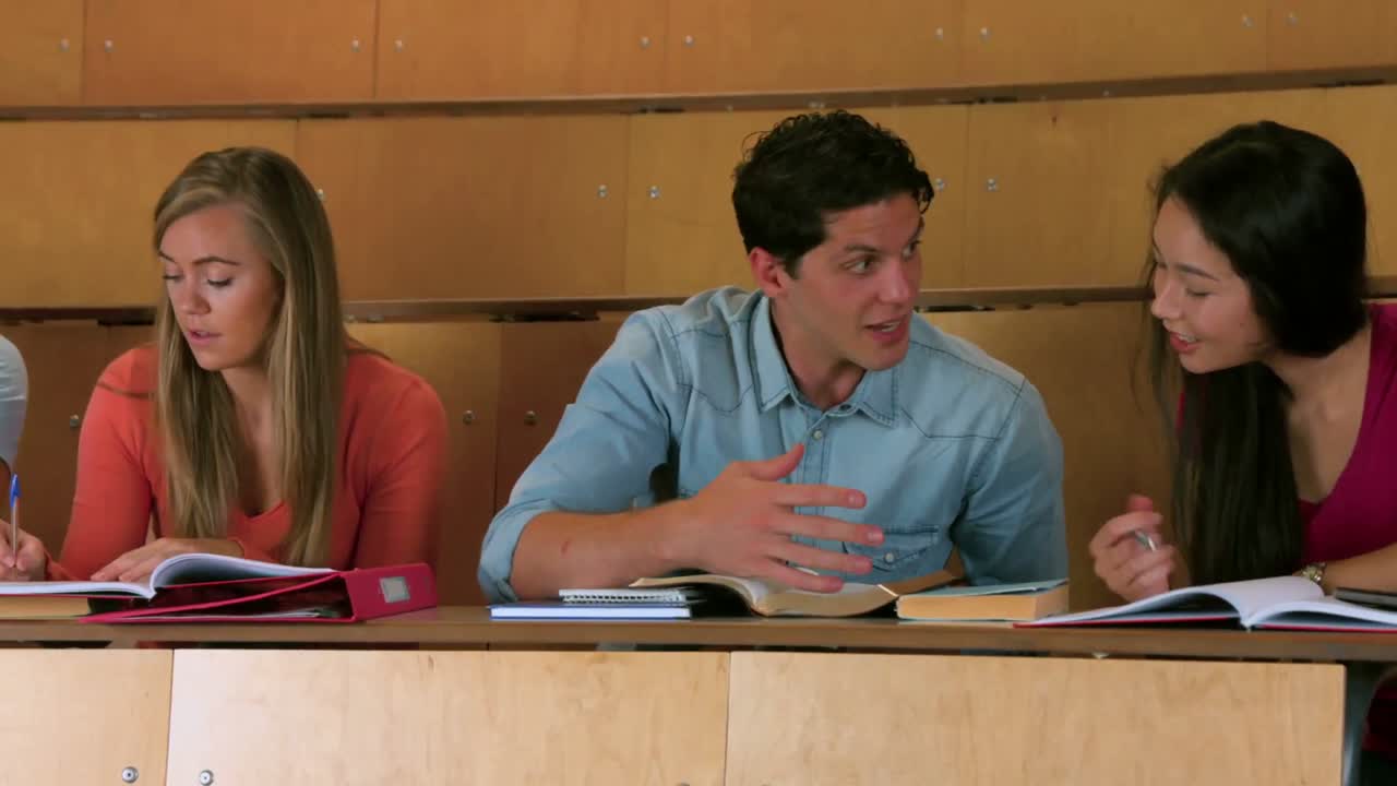 estudiantes sentados uno al lado del otro mientras aprenden