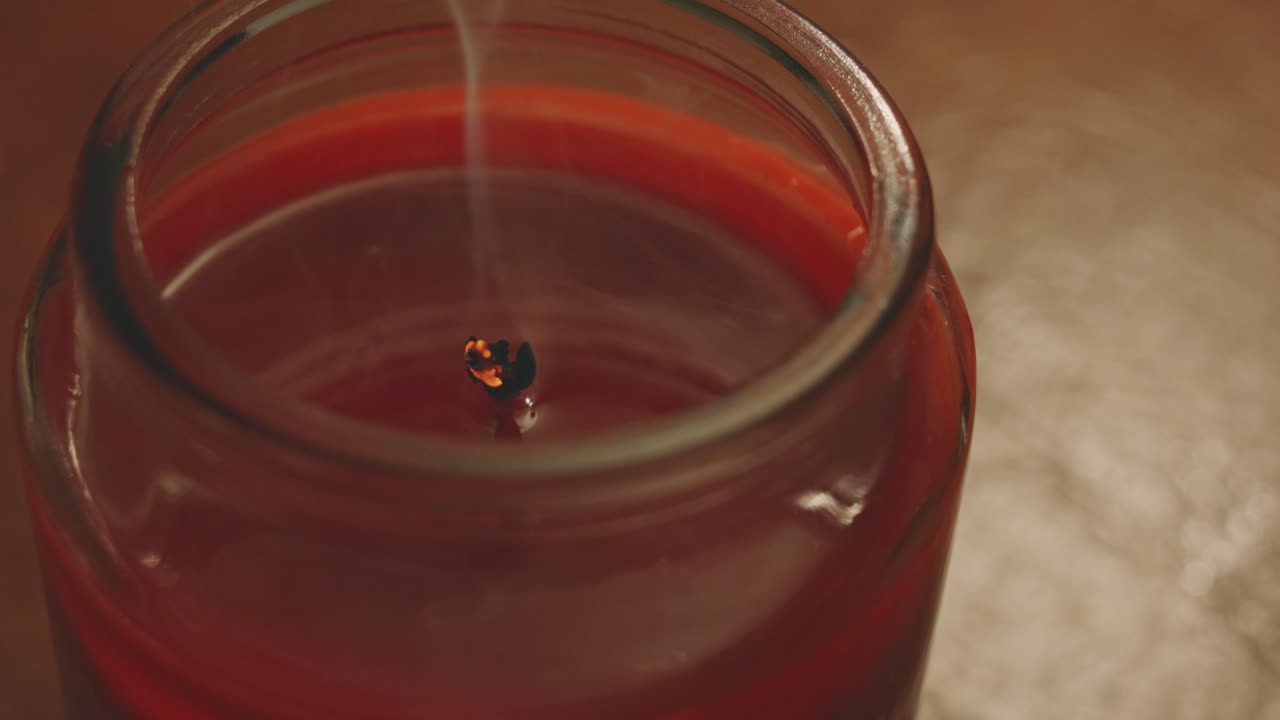 유리 컵에 촛불을 태우고 어둠 속에서 부는 불 바람