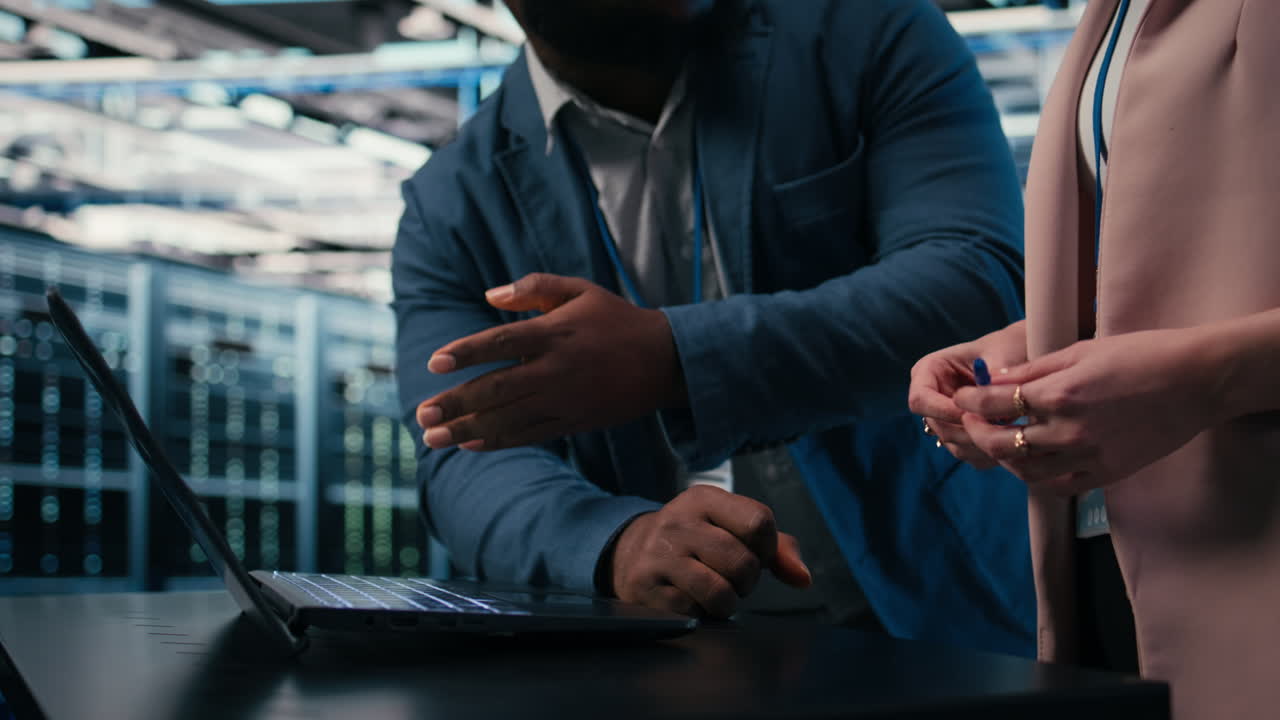 IT Professionals Discussing Data Center Operations on Laptop