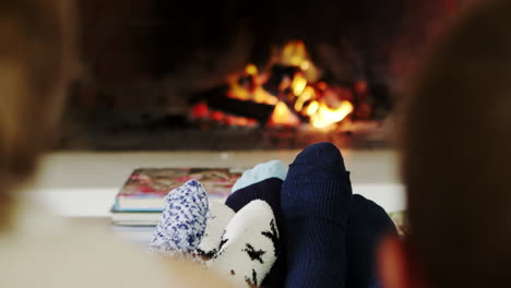 close up of family warming feet by open fire