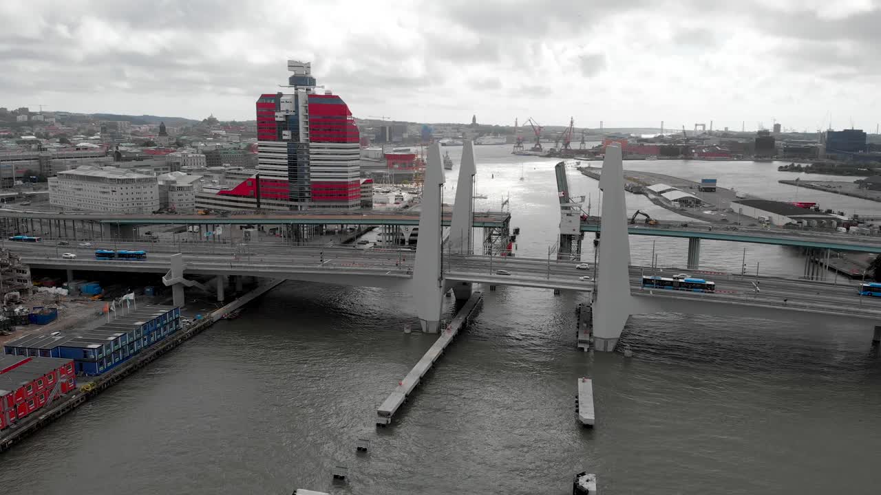 흐린 날씨, 스웨덴 예테보리 시내 배경에 릴라 봄멘 건물이 있는 히싱스브론 다리에서 고타 강을 건너는 차량을 포착한 공중 돌리