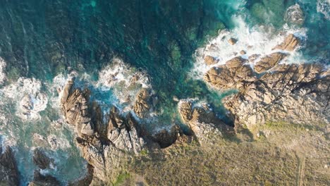 Vista-De-Pájaro-Sobre-Olas-Espumosas-Que-Salpican-En-La-Costa-Rocosa-En-Cabo-De-San-Adrián,-España---Disparo-De-Drones