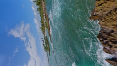 vuelo vertical en fpv sobre islas tropicales con el mar caribeño ondulado y palmeras durante el verano - playa los coquitos, república dominicana