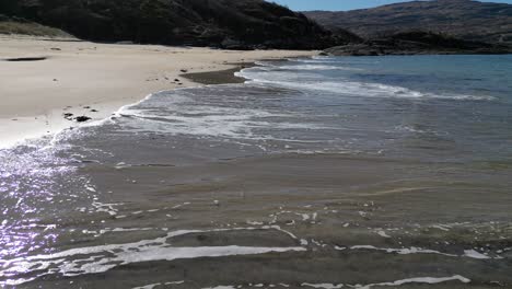 Gentle-waves-crashing-on-sandy-Scottish-beach---Camas-an-Lighe---aerial