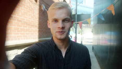 young man taking a selfie in an urban alley