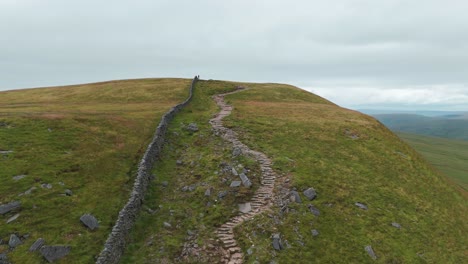 Aerial-Trail-hike-patch-dry-stone-wall,-Lake-District-national-park-United-Kingdom-UK