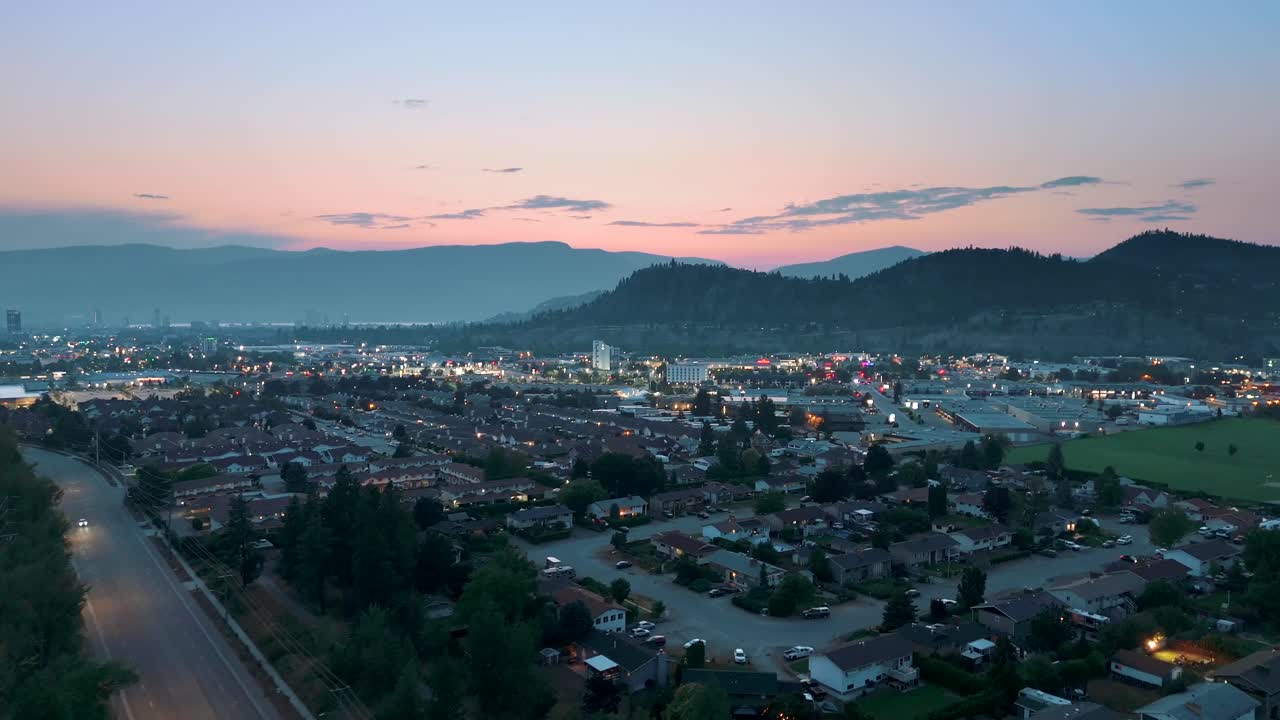 Experience a stunning aerial view of Kelowna at sunset, highlighting the city’s transformation and growth against a backdrop of vibrant colors in the sky.