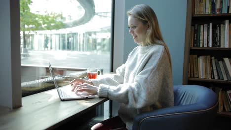 Woman-in-comfortable-armchair-using-laptop