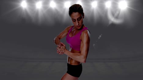 Animation-of-strong-muscular-woman-in-pink-top-and-black-shorts-over-spotlights