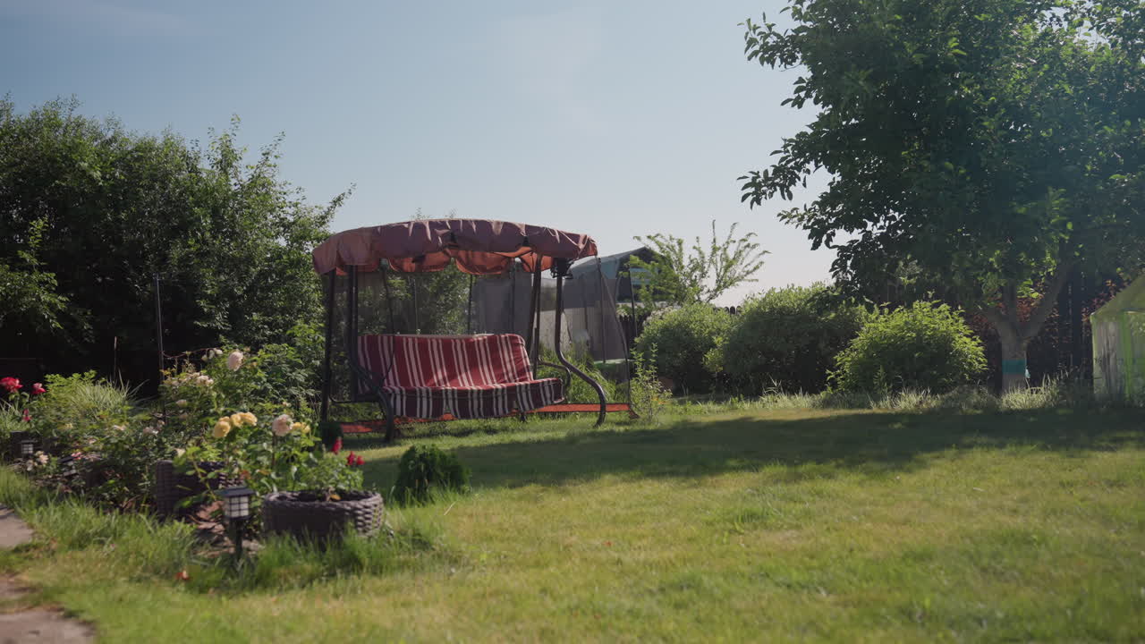 Peaceful Garden Retreat, Quiet Garden Setting Featuring Comfortable Swing And Blossoming Plants, Serene Outdoor Environment With Cushioned Swing Surrounded By Vibrant Flowers And Expansive Lawn