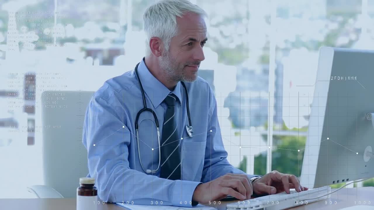 médico caucásico trabajando en la computadora y luego mirando a la cámara con una sonrisa