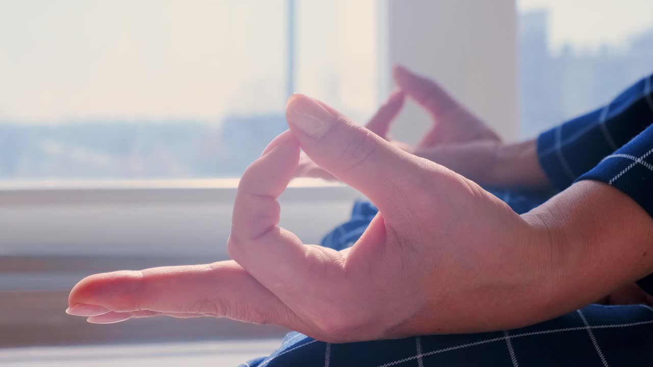 A Moment of Mindfulness: A Person Practicing Meditation in a Sunlit Room, Showcasing Relaxation Techniques and Inner Peace through Hand Gestures