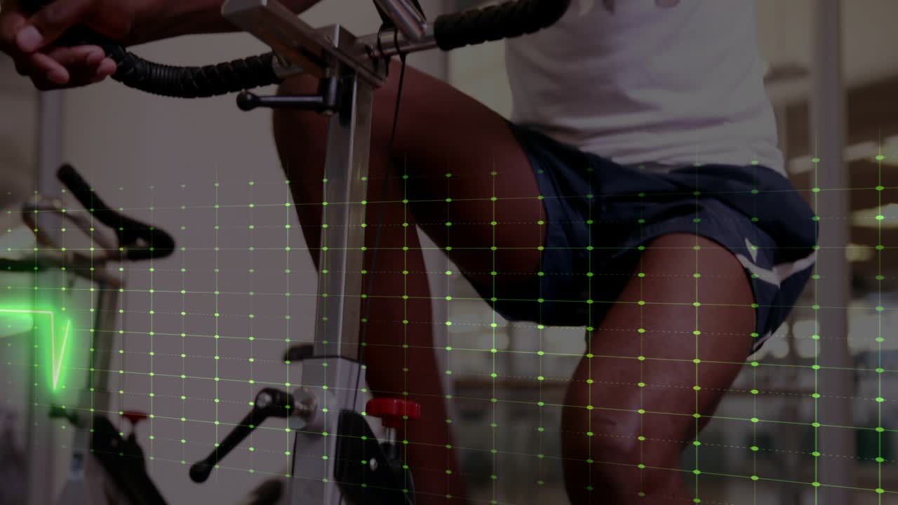 Man pedaling bike in gym, causing green ECG grid overlay tracking heart rate, wiping towel, slowing