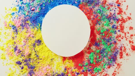 video of multi coloured powders and white circle with copy space on white background