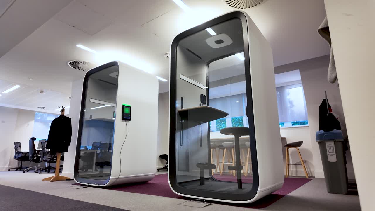 Modern office equipped with soundproof pods ensuring privacy for focused work and phone calls. Low Angle, Rising Shot