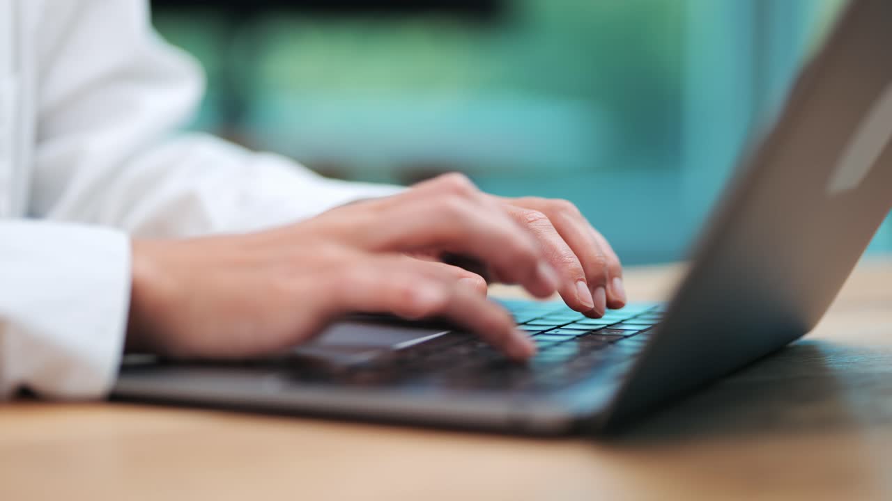 Digital Entrepreneurship: Woman's Hands Typing on MacBook Keyboard in Modern Business Workspace