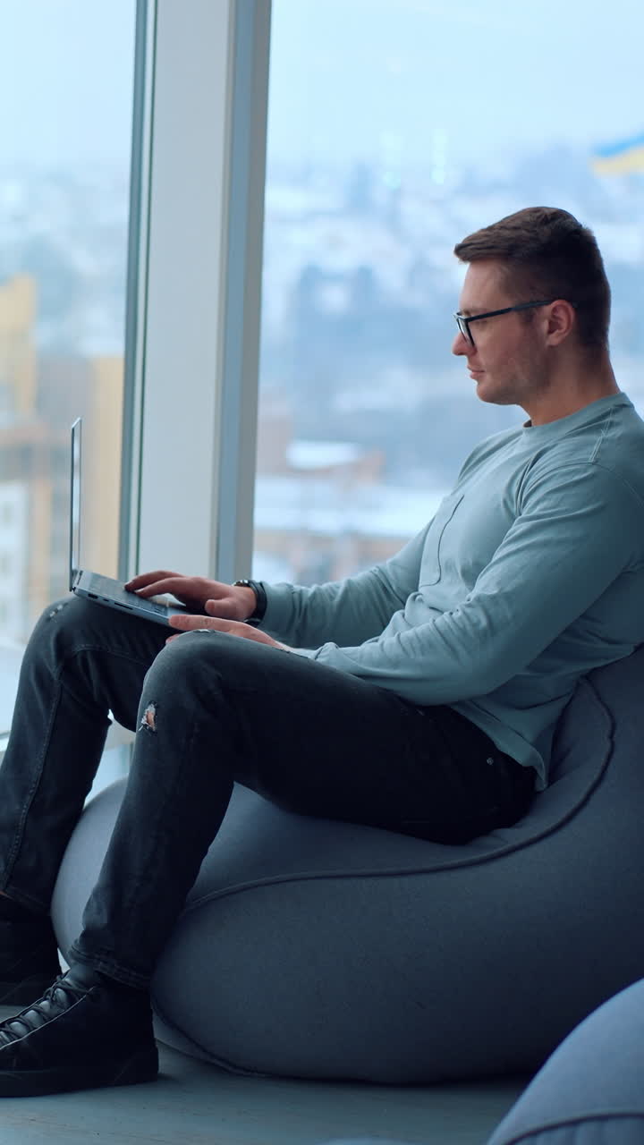 Professional businessman typing on computer. Young entrepreneur working with laptop. Vertical video