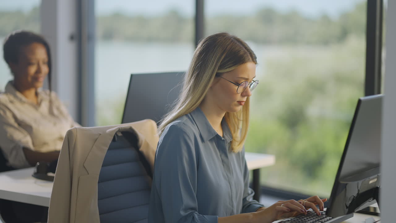 Two women working on computers in an office
