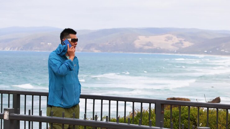 mann spricht am strand am telefon