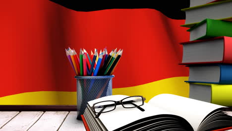 school accessories on a table with german flag floating