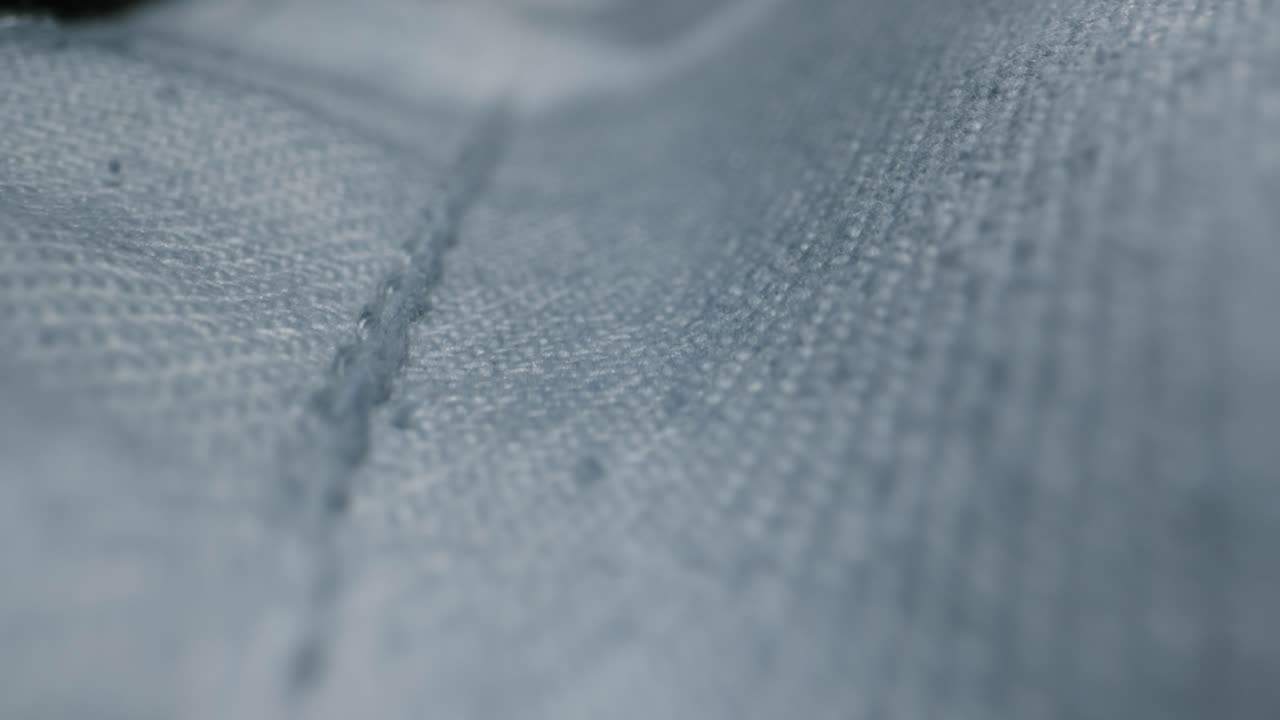 Close-up view of denim fabric texture with rips and stitching