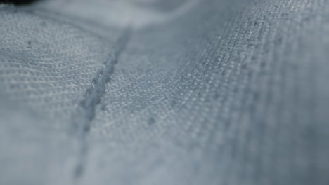 close-up view of denim fabric texture with rips and stitching