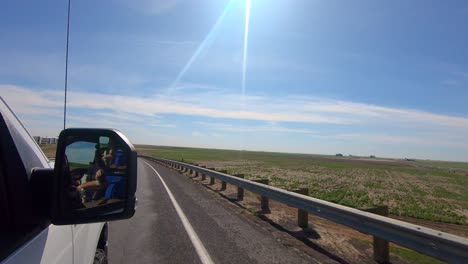 pov out of the passenger's side window while driving past harvested wheat fields in an agricultural area of eastern washington state