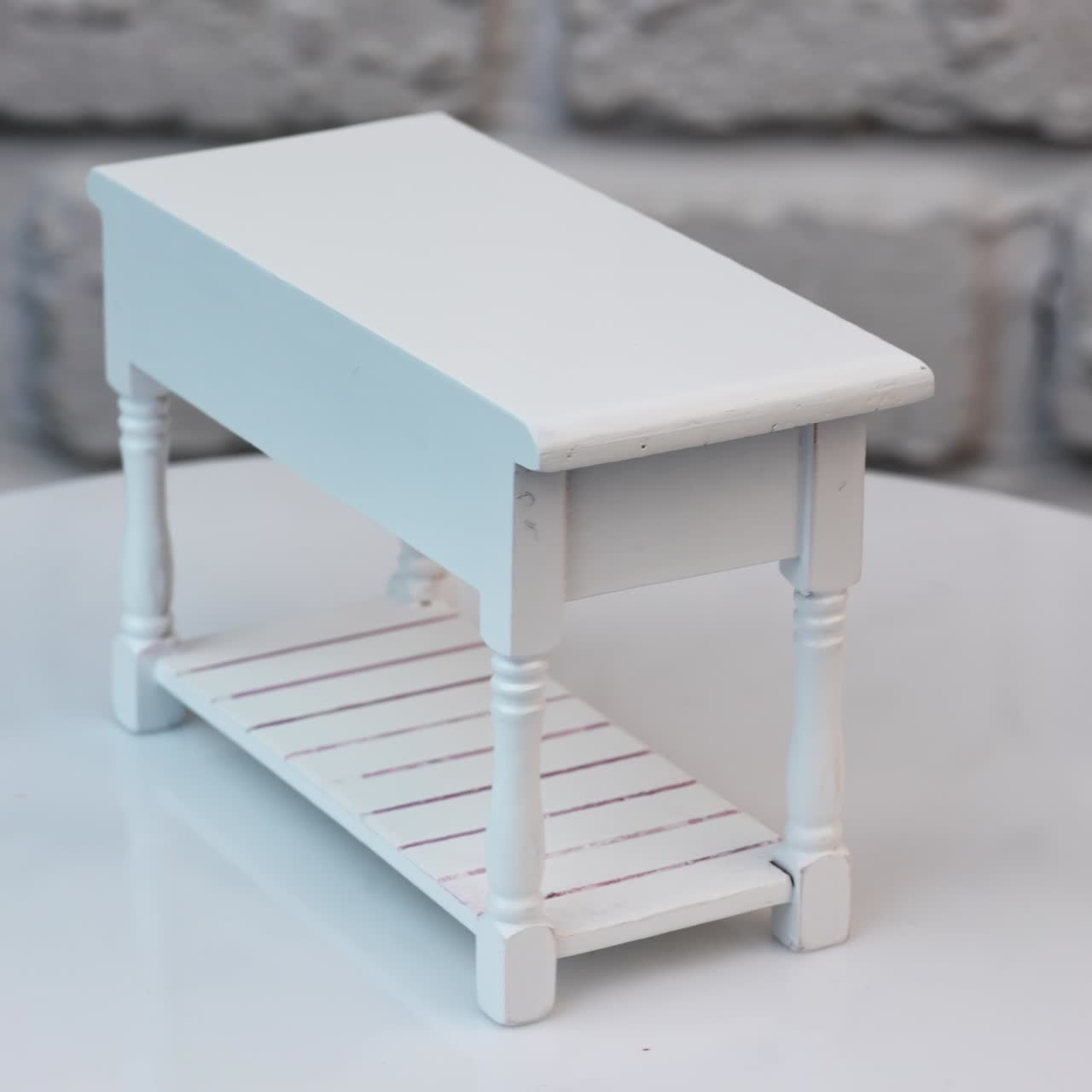 White piece of miniature furniture. Cute wooden table with drawers rotating. Close up