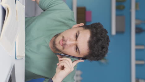 Vertical-video-of-Male-student-speaking-angrily-on-the-phone.