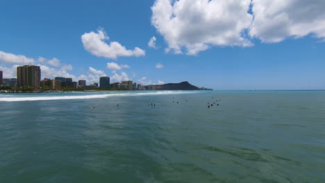 waiting for the swell, aerial drone fpv shot over surfers on gorgeous blue water of oahu