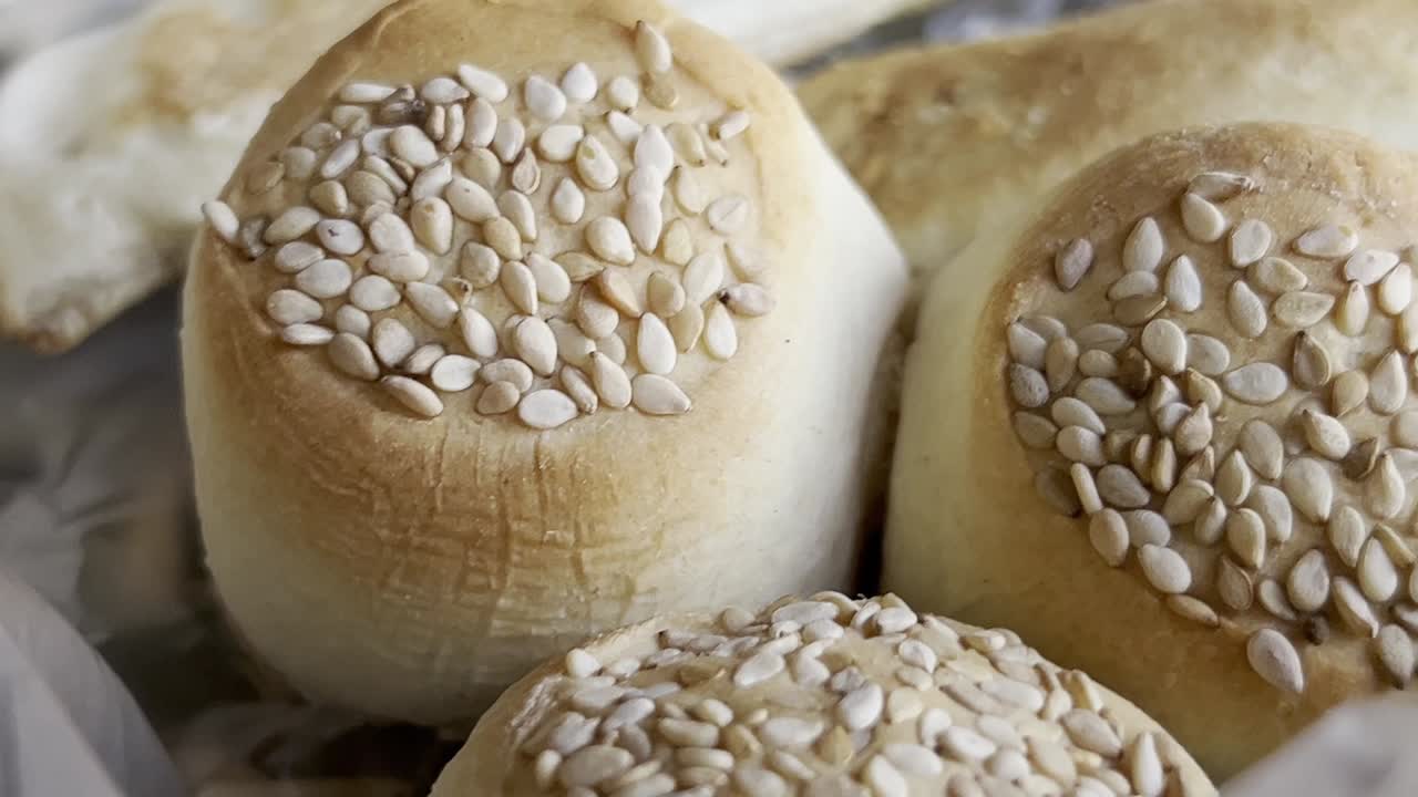 신선하게 구운 의 클로즈업은 세자미 씨를 관대하게 뿌려서 시각적으로 매력적인 질감을 만들어 맛있는 향기를 암시합니다.